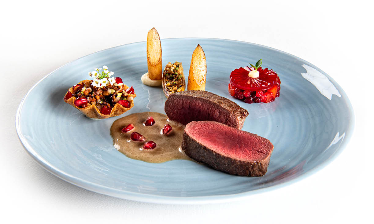 Ribstuk van ree met jeneverbessen, taartjes met bospaddenstoelen, schorseneren, veenbessen en granaatappel